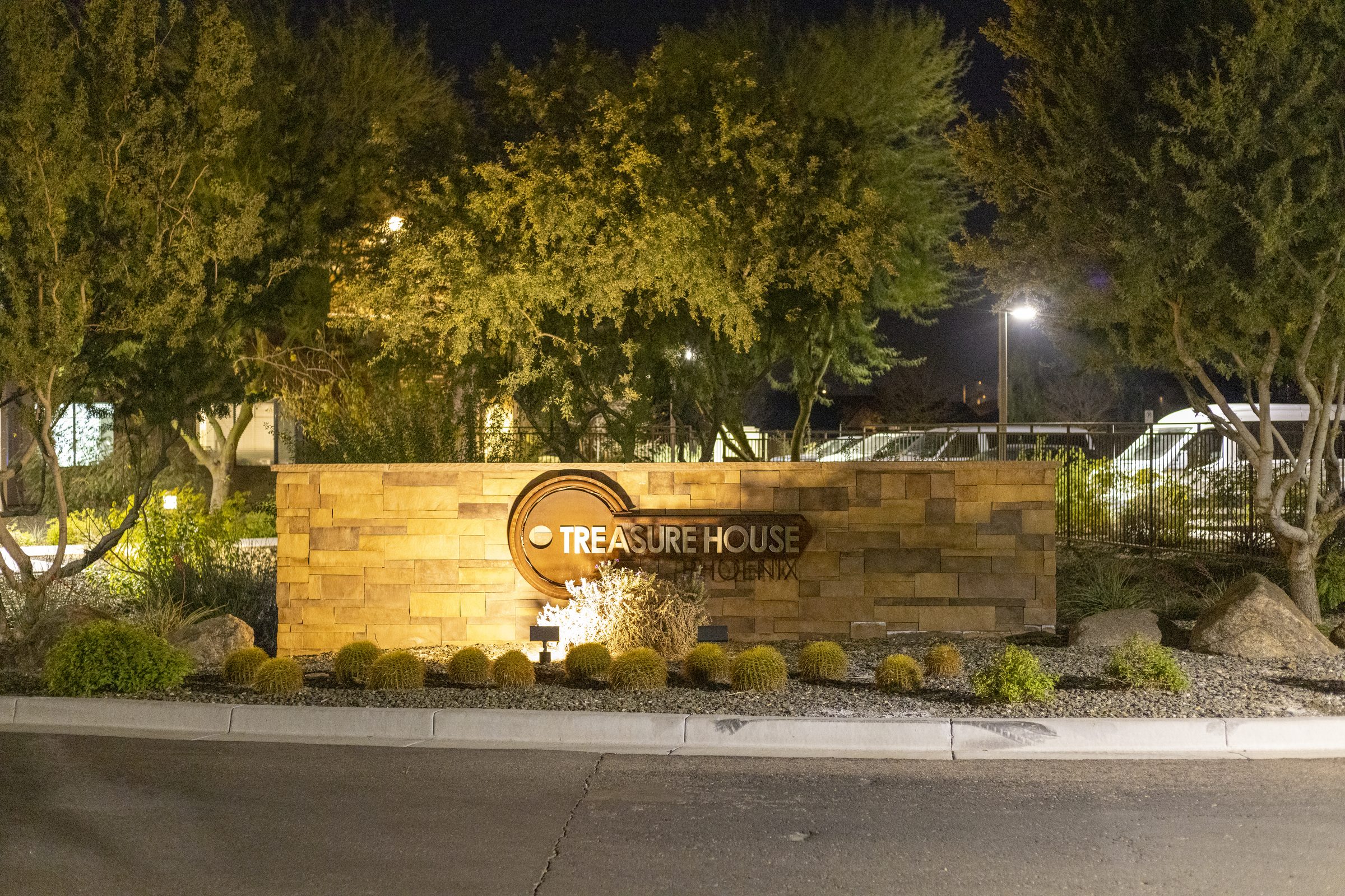 The Treasure House entrance sign lit at night