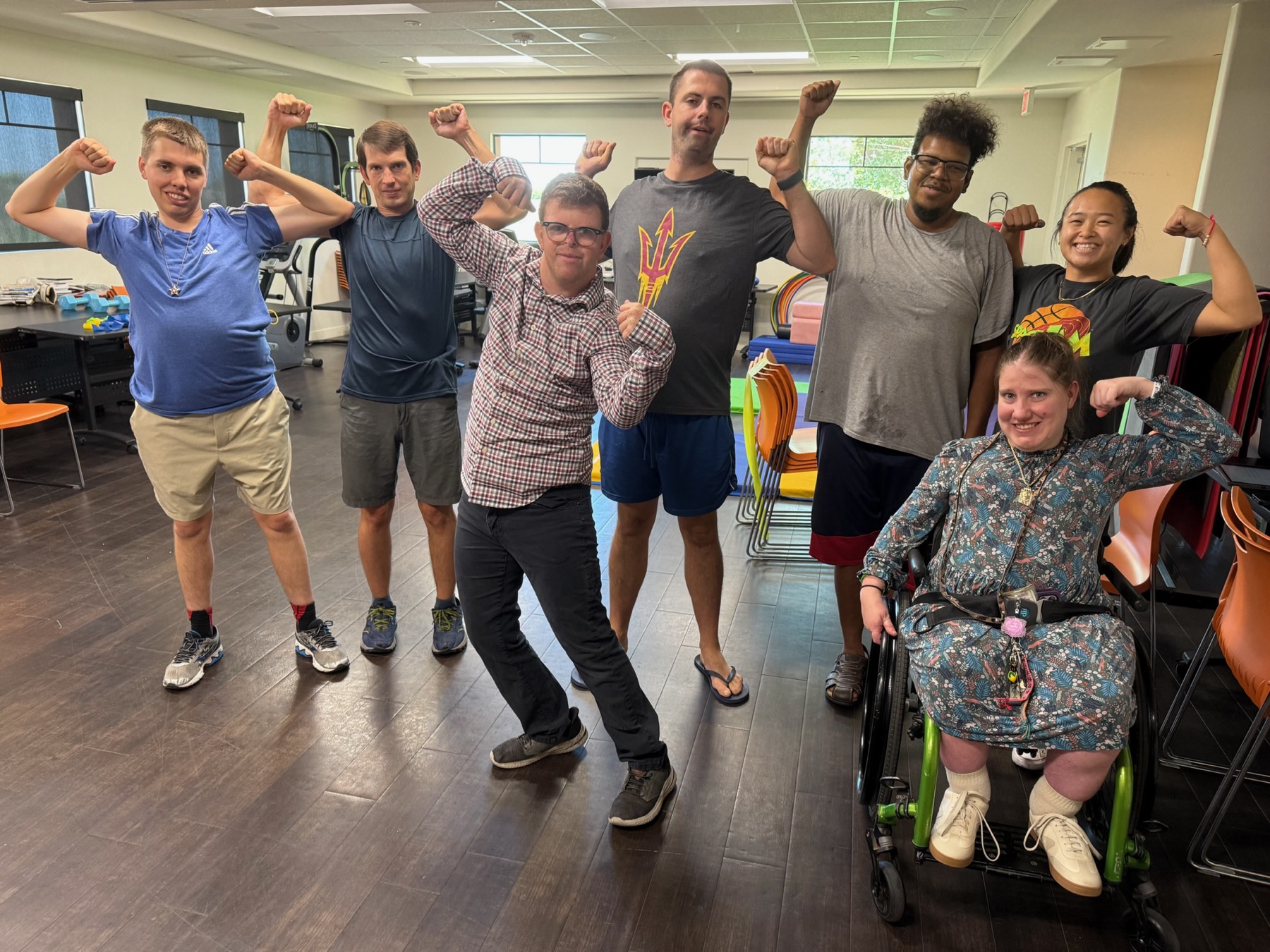 Residents and staff flexing together after a fitness class at Treasure House
