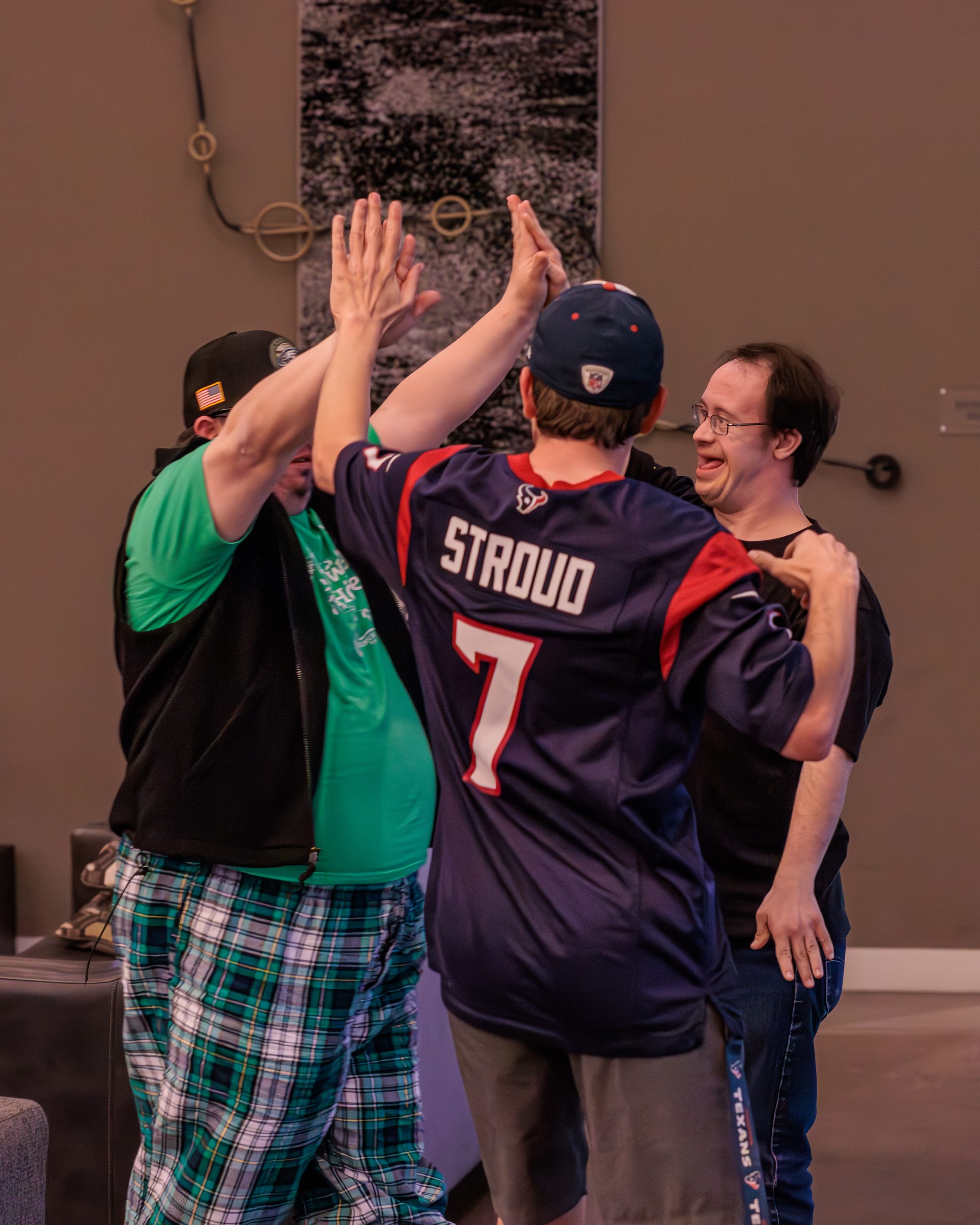 Two residents high-fiving in the game room